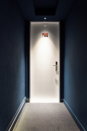 Un pasillo que conduce a una puerta con el número 706 iluminado arriba.