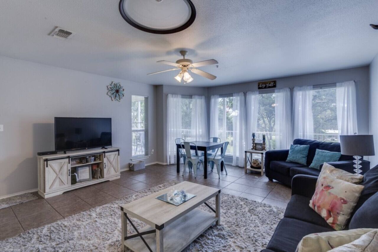 A living room with a TV, a dining table, and a sofa.