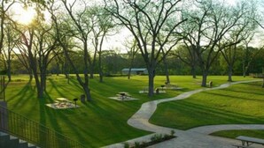 A park with a winding path, picnic tables, and benches.