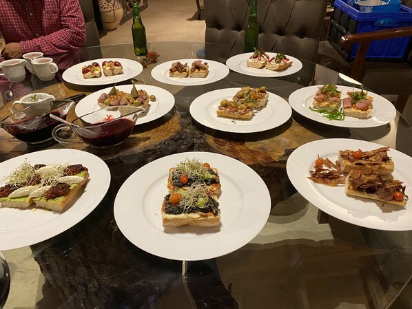 Une table à manger avec divers amuse-gueules et boissons.