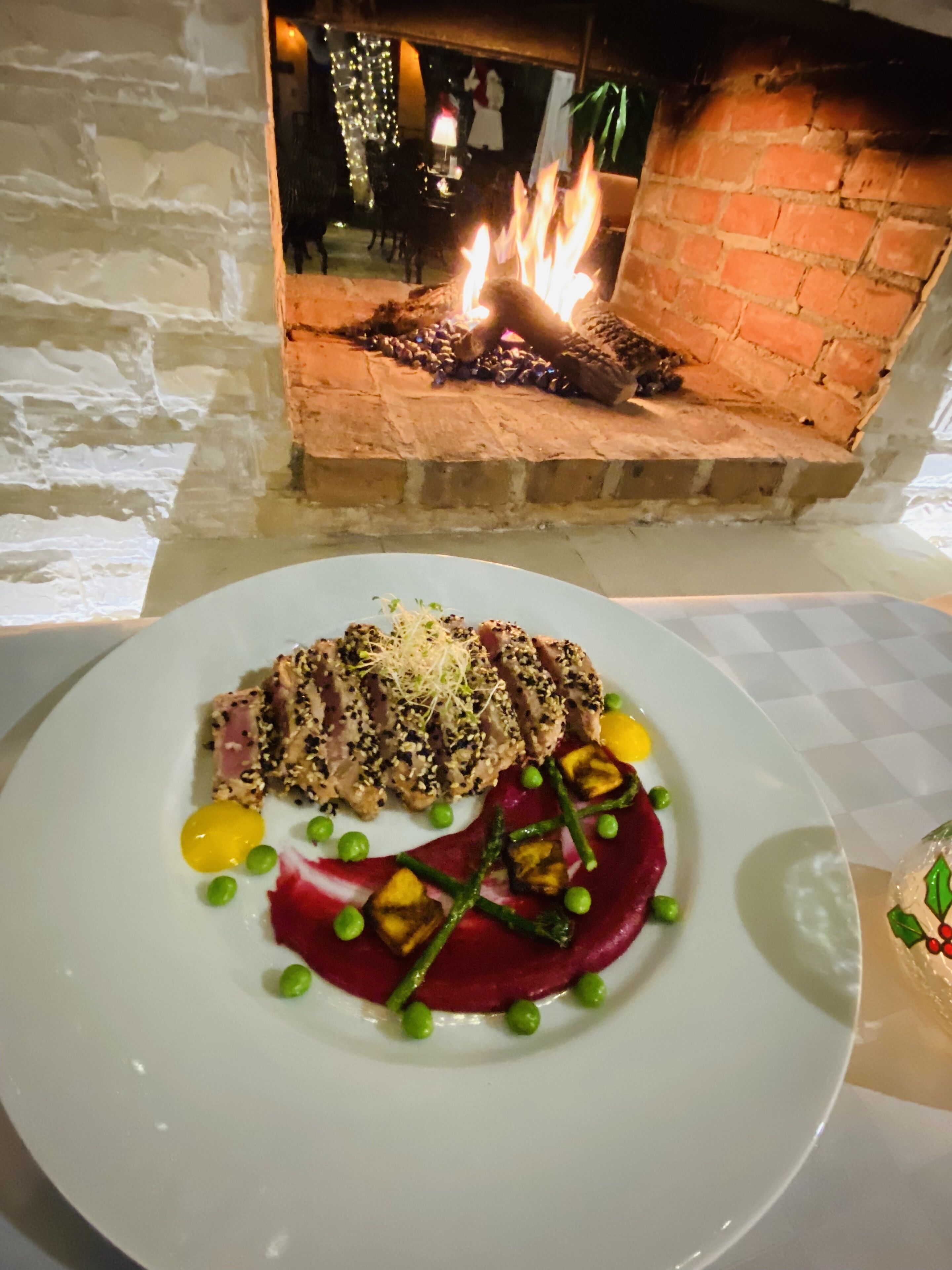 A plate of food with a fire feature in the background.