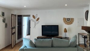 Un soggiorno con un divano, una televisione e decorazioni murali.