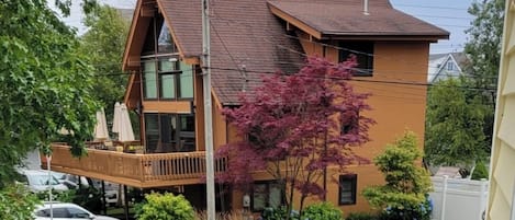 A wooden deck with blue Adirondack chairs and a starfish decoration.