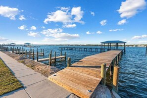A wooden pier extending into calm water with a clear sky.