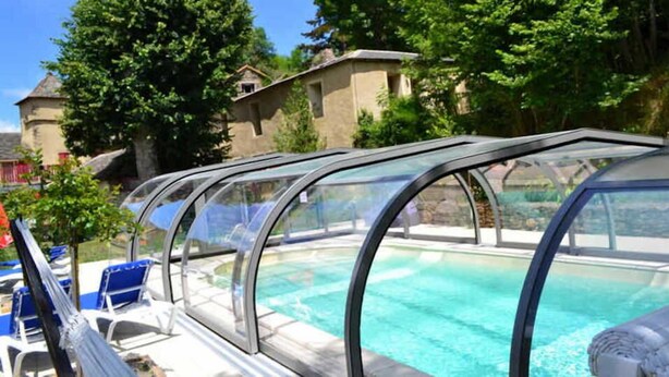 A swimming pool with clear water, surrounded by lounge chairs and covered seating areas. - Les Copains à Bord - Gîte D'étape (Cans et Cévennes)