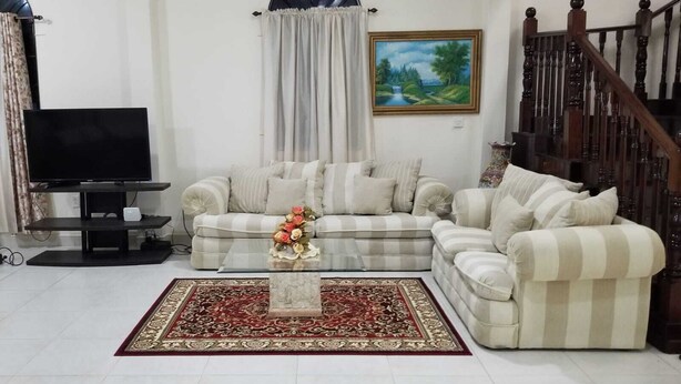 A living room with a sofa set, a coffee table, a TV, and a staircase. - Exquisite Accommodation in Gated Community (Versailles)