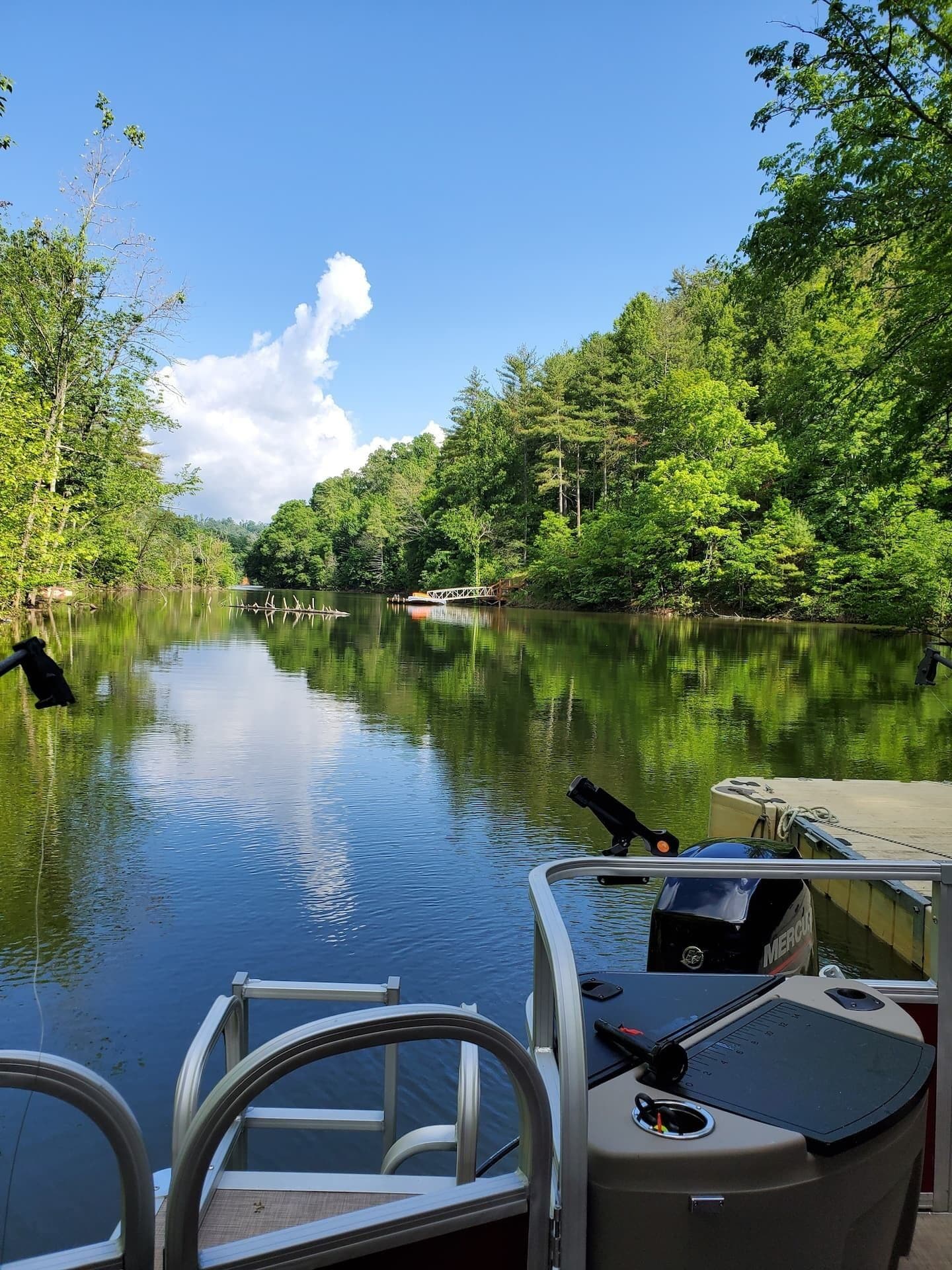 A boat docked at a calm river with lush greenery on both sides.