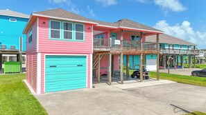 A two-story house with a garage, a balcony, and a covered porch area.