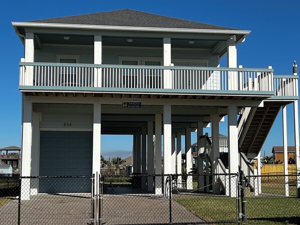Ein zweistöckiges Gebäude mit Balkon, Garage und Treppe.