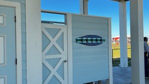 A covered outdoor area with a wooden door, a white gate, and a concrete floor. - La Casa Bonita: 2  BR, 2  BA House in Crystal beach, Sleeps 8 (Bolivar Peninsula)