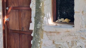 A stone building with a wooden door and a window with mosaic glass. - This home features lush garden & private pool. (Isla mujeres)