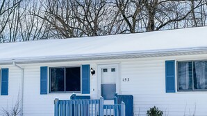 A white mobile home with blue shutters and a number '153' on the door.