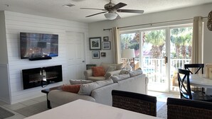 A living room with a TV, fireplace, sofa, and dining area. - Welcome to Rollin Tide Villas in the heart of beautiful 30A. (Santa Rosa Beach)