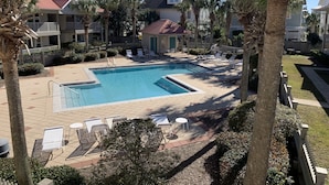 A pool area with lounge chairs and a small building, surrounded by palm trees and a fence. - Welcome to Rollin Tide Villas in the heart of beautiful 30A. (Santa Rosa Beach)