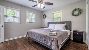 A bedroom with a bed, a nightstand, a ceiling fan, and two windows with blinds. - Marietta! Near the Square, Pets & Long stays ok. Entire home (Marietta)