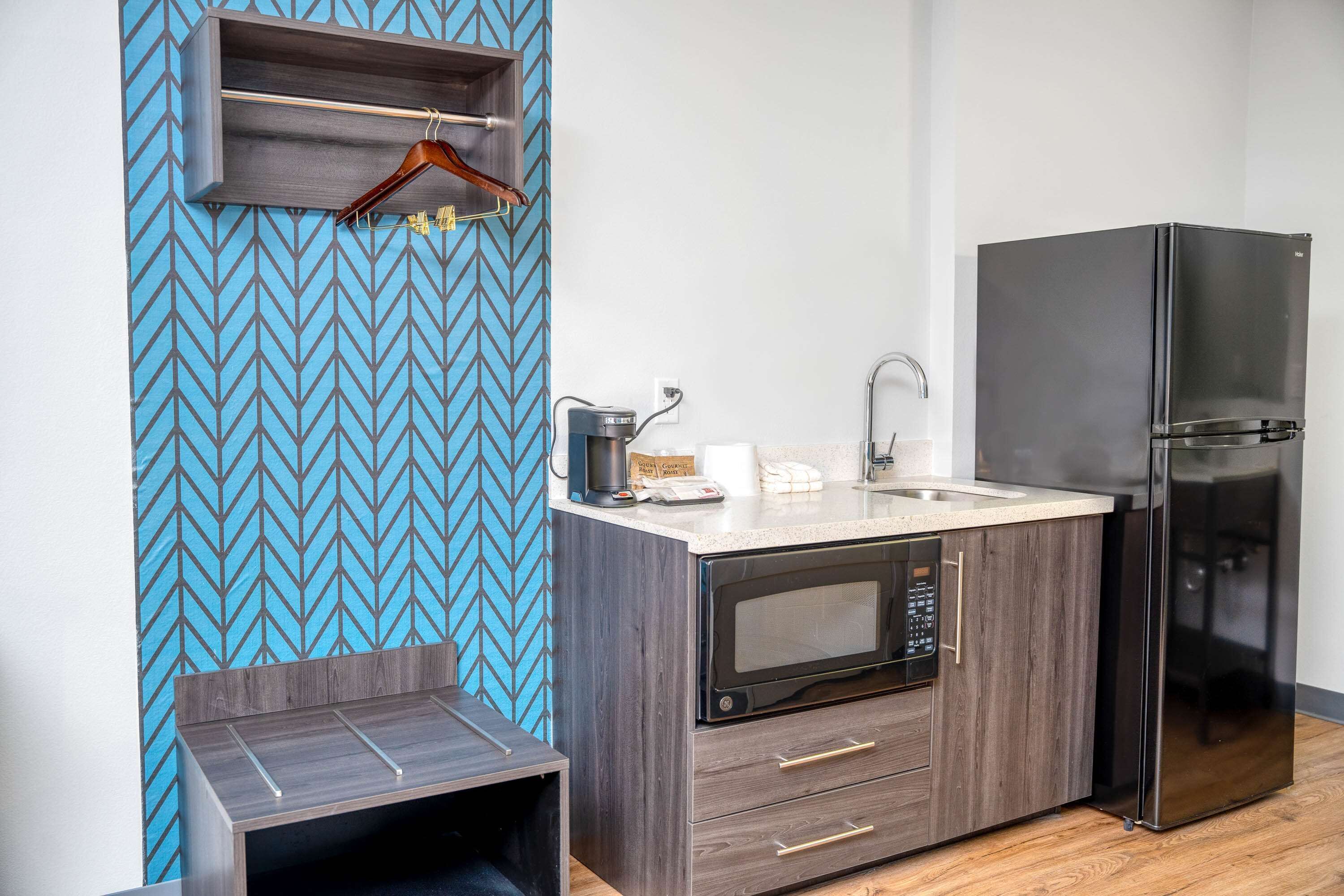Una cocina compacta con microondas, refrigerador y una pequeña superficie de encimera.