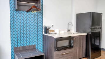 A compact kitchen with a microwave, refrigerator, and a small countertop area.