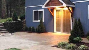 Une maison à deux étages dotée d’un porche avant couvert et d’un mur de soutènement en pierre.