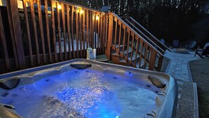A hot tub with a wooden deck and stairs leading up to it. - Private Heated Pool/Hot Tub/Huge Game Room/Sauna/Fire Pit/Huge Yard/3300 sq ft! (Stroudsburg)