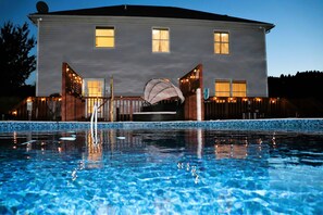 A swimming pool with a house in the background.