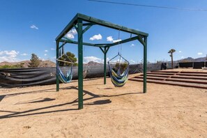 Relax in a serene, open-air space with two hammocks suspended from a metal frame.