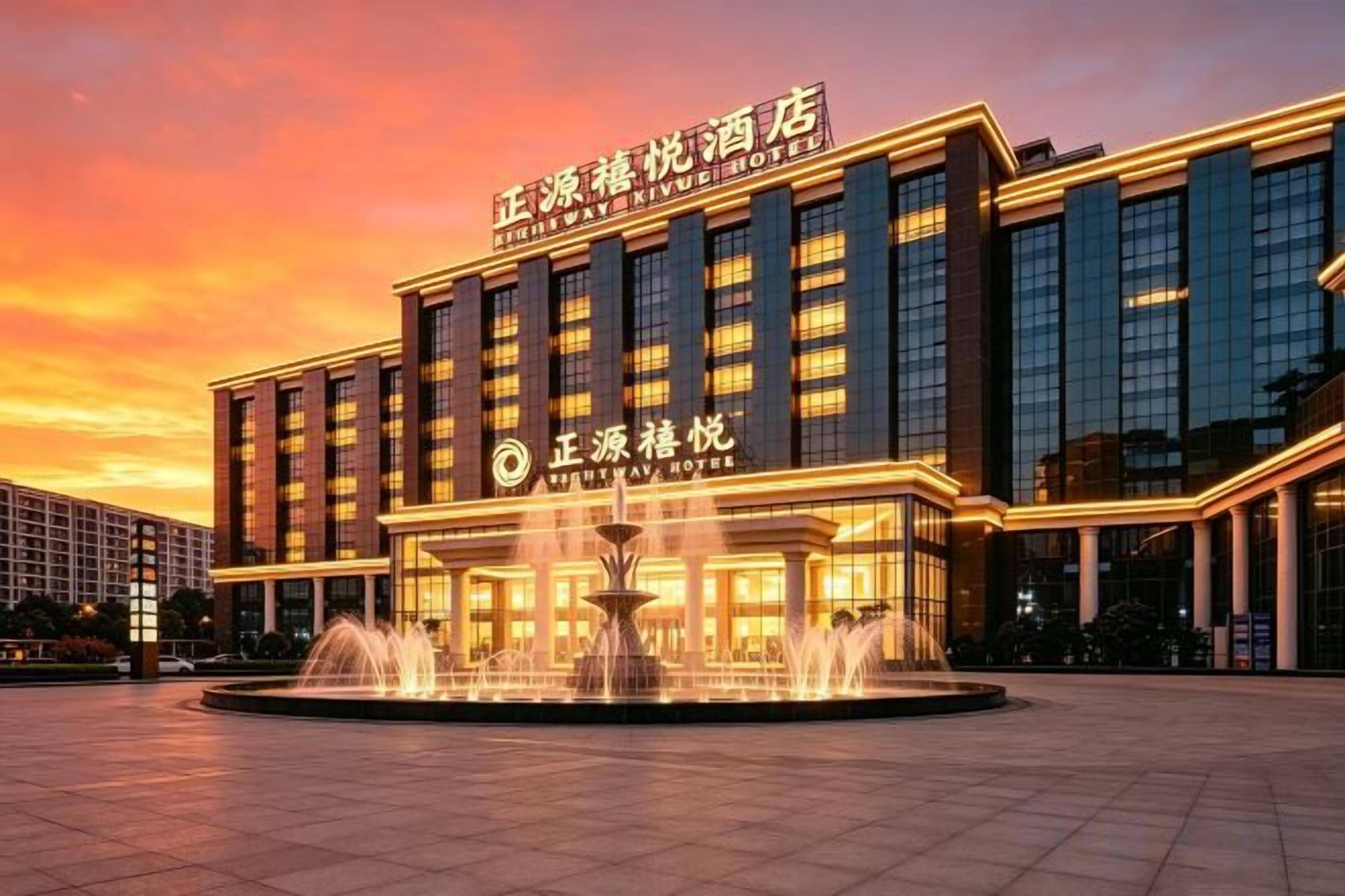 A hotel with a large entrance, a fountain in front, and a clear sky.