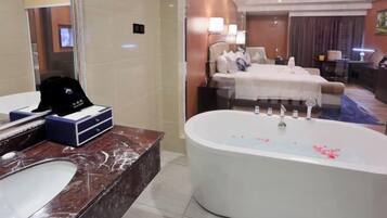 A bathroom with a marble sink, a bathtub, and a large mirror.