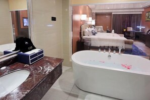 A bathroom with a marble sink, a bathtub, and a large mirror. - Rightway Xiyue Hotel (Chengdu)