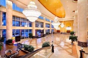 A spacious lobby with large chandeliers, marble columns, and a glass facade. - Rightway Xiyue Hotel (Chengdu)