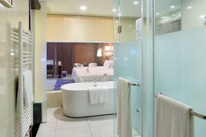 A modern bathroom with a bathtub, a shower, and a glass partition. - Rightway Xiyue Hotel (Chengdu)