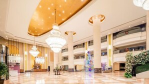A spacious lobby with high ceilings, chandeliers, and a central decorative column. - Rightway Xiyue Hotel (Chengdu)