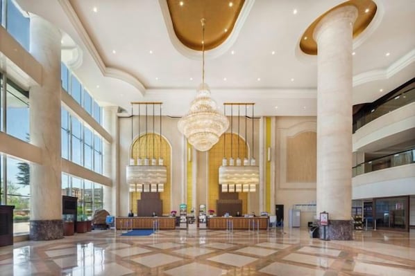 A spacious lobby with a high ceiling, large chandeliers, and a check-in counter. - Rightway Xiyue Hotel (Chengdu)