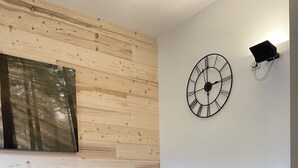 Une table à manger en bois avec des chaises, une horloge au mur et un plancher en bois.