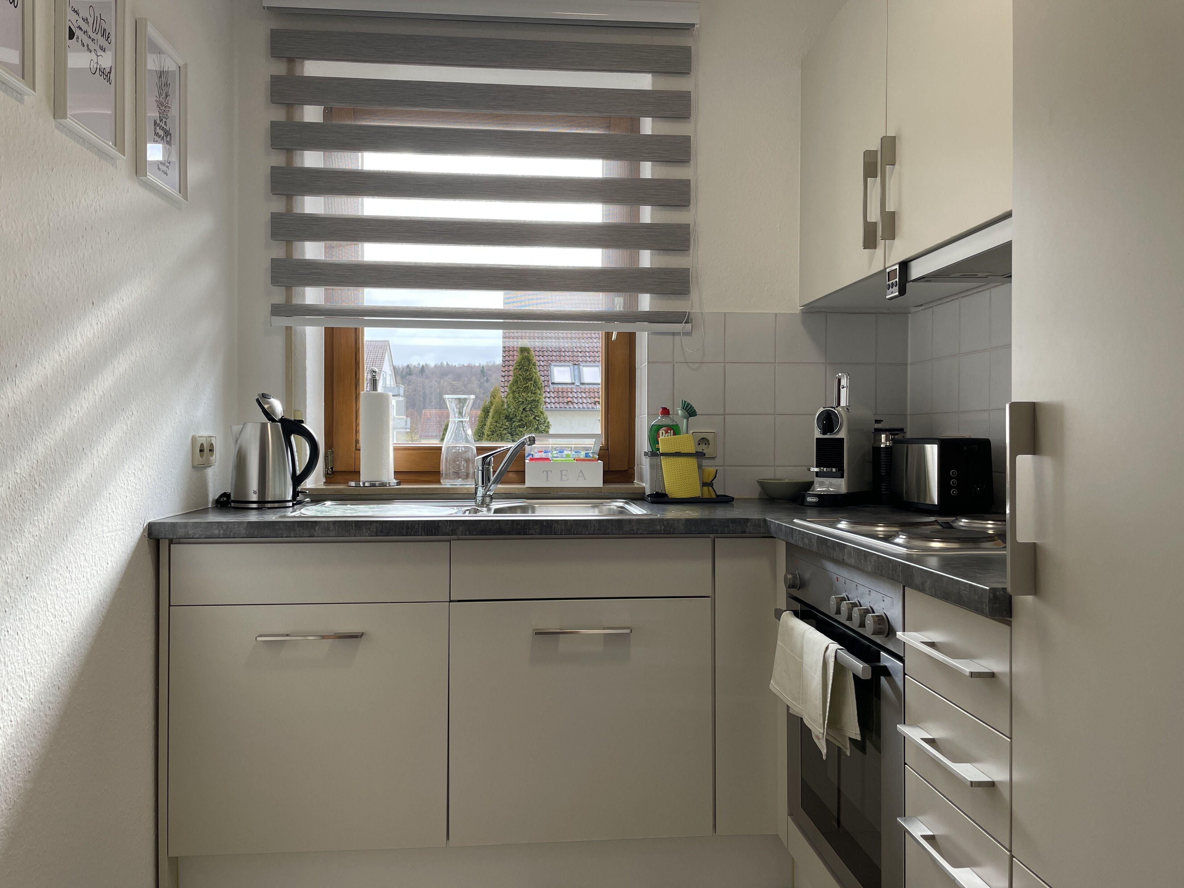 Eine moderne Küche mit Backofen, Mikrowelle und Kaffeemaschine.