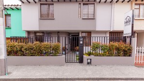 A two-story hotel with a gated entrance, a sign indicating it is a Casa Hotel, and a parking sign. - Ayenda Casa La Castellana (San Juan de Pasto)