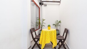 A small patio with a table covered by a yellow polka dot tablecloth, two chairs, and two potted plants. - Ayenda Casa La Castellana (San Juan de Pasto)