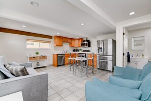 Una cocina moderna con electrodomésticos de acero inoxidable, armarios de madera y una isla central.