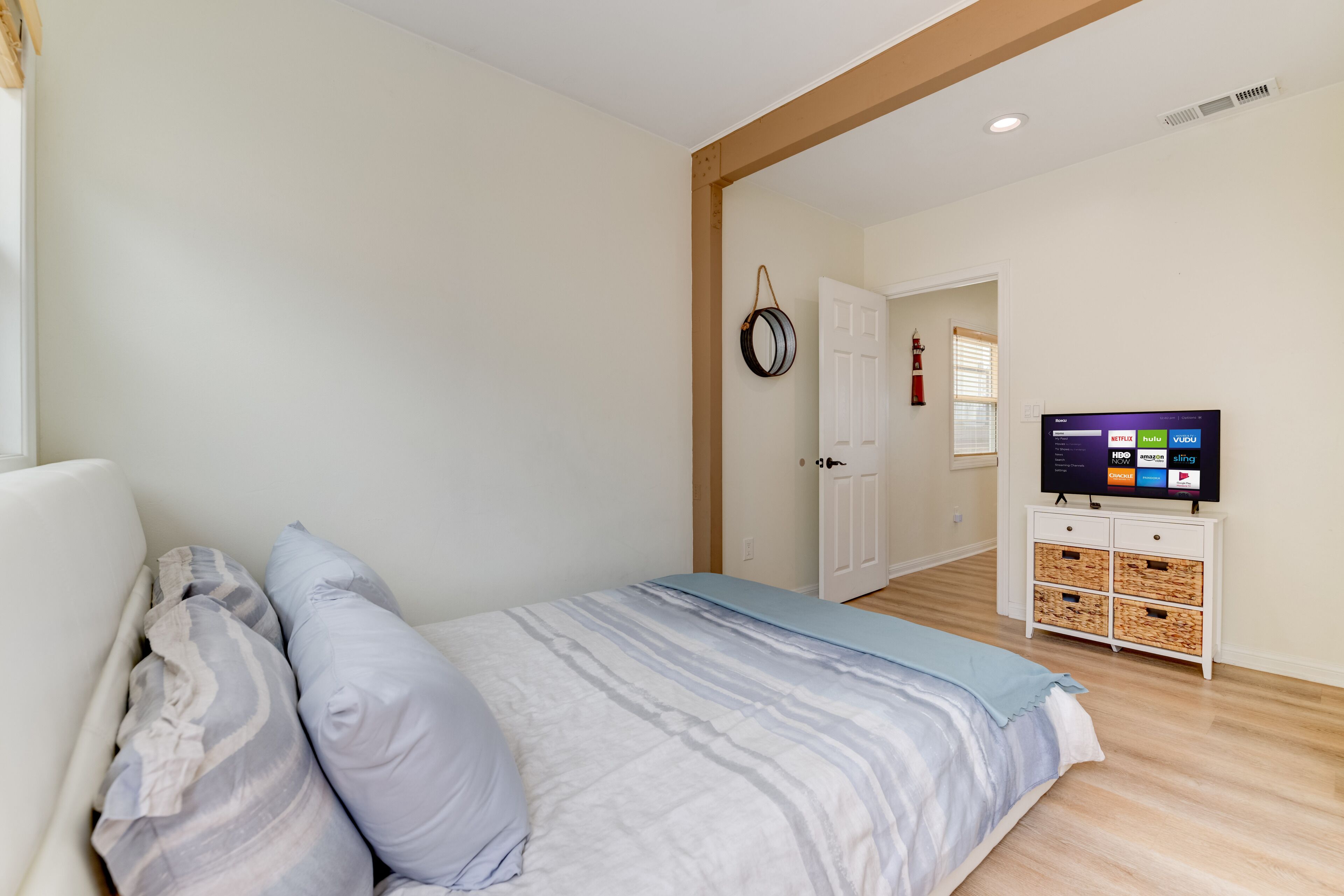A bedroom with a bed, pillows, a TV, and a storage unit.