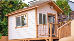 A small, single-story house with a balcony and a wooden staircase. - Cozy 3BR Renovated Home with Scenic Views! Near Downtown/Airport/Gaslamp Quarter (San Diego)