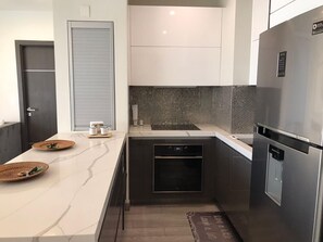 Apartemen Grand | Dapur pribadi | Kompor, peralatan masak/sendok-piring, dan perlengkapan kebersihan