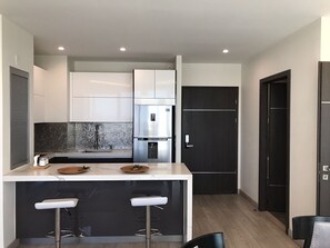 Departamento Grand | Cocina privada | Parrilla de estufa, utensilios de cocina y artículos de limpieza