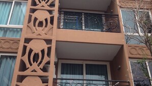 A multi-story building with balconies and decorative patterns on the facade. - Aitalay Condotel Jomtien (Pattaya)