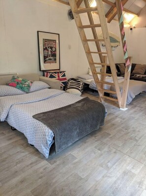 Relax in this inviting bedroom with a large bed, wooden ladder, and personal touches.