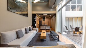 Un salon moderne comprenant un canapé, une table basse et un coin repas avec des chaises.