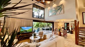 Un espacio habitable amplio con un televisor grande, asientos cómodos y vistas al exterior.
