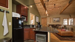 A kitchen with a black refrigerator, a microwave, and a built-in oven. There is a wooden ceiling with exposed beams and pendant lighting. - ⭐️Premier Host - Serene cabin, the best amenities, north end of James Ranch  (Durango)