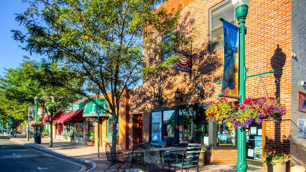 A street with outdoor seating, brick buildings, and hanging flower baskets. - RED ROCKS RETREAT!  Great Location! Close to Amenities! Awesome deck with games. (Wheat Ridge)