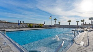 A swimming pool with clear blue water, surrounded by lounge chairs and palm trees. - Book 3 Nights & Get 1 Free-See Description* Beachfront*Tram* Pool *Stunning View (Miramar Beach)