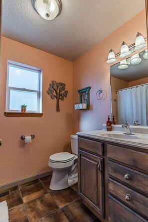 Un bagno con il water, un lavabo e una finestra.
