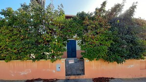 Un bâtiment avec une porte bleue, une enseigne indiquant « VENTES » et le chiffre « 36 » sur le mur.